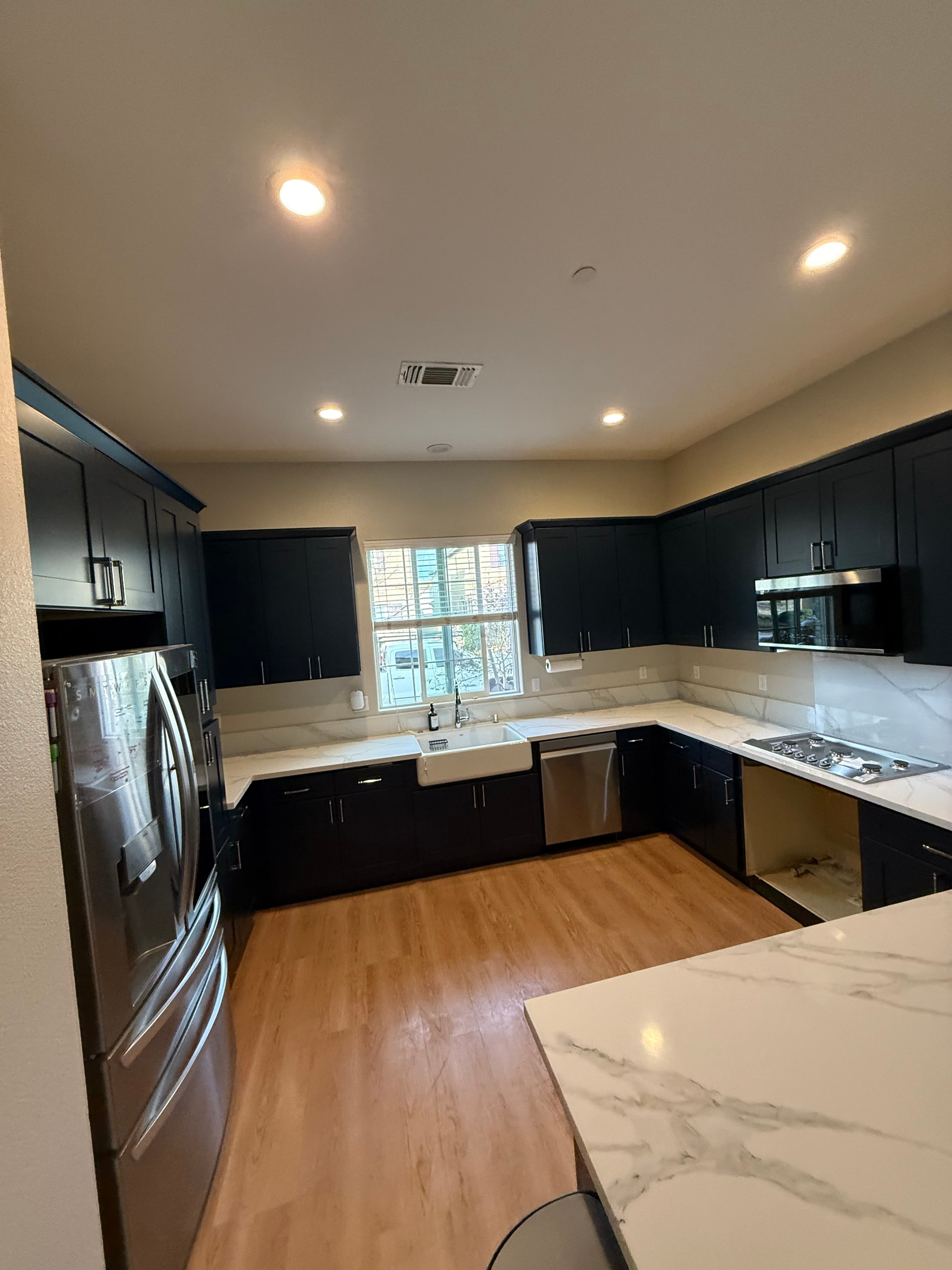 Kitchen remodel with dark cabinetry and marble countertops