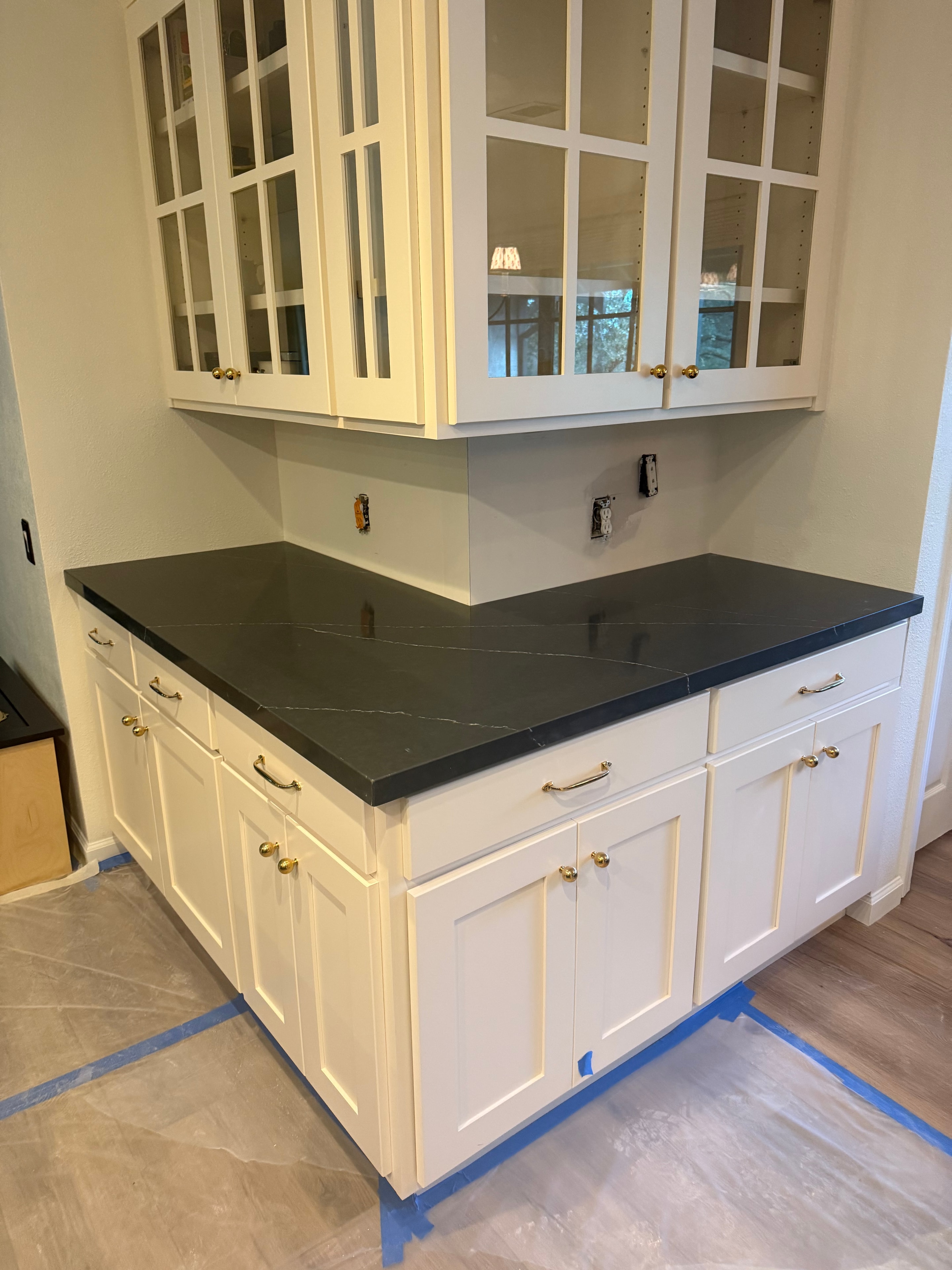 Custom white cabinetry with dark stone countertop installation