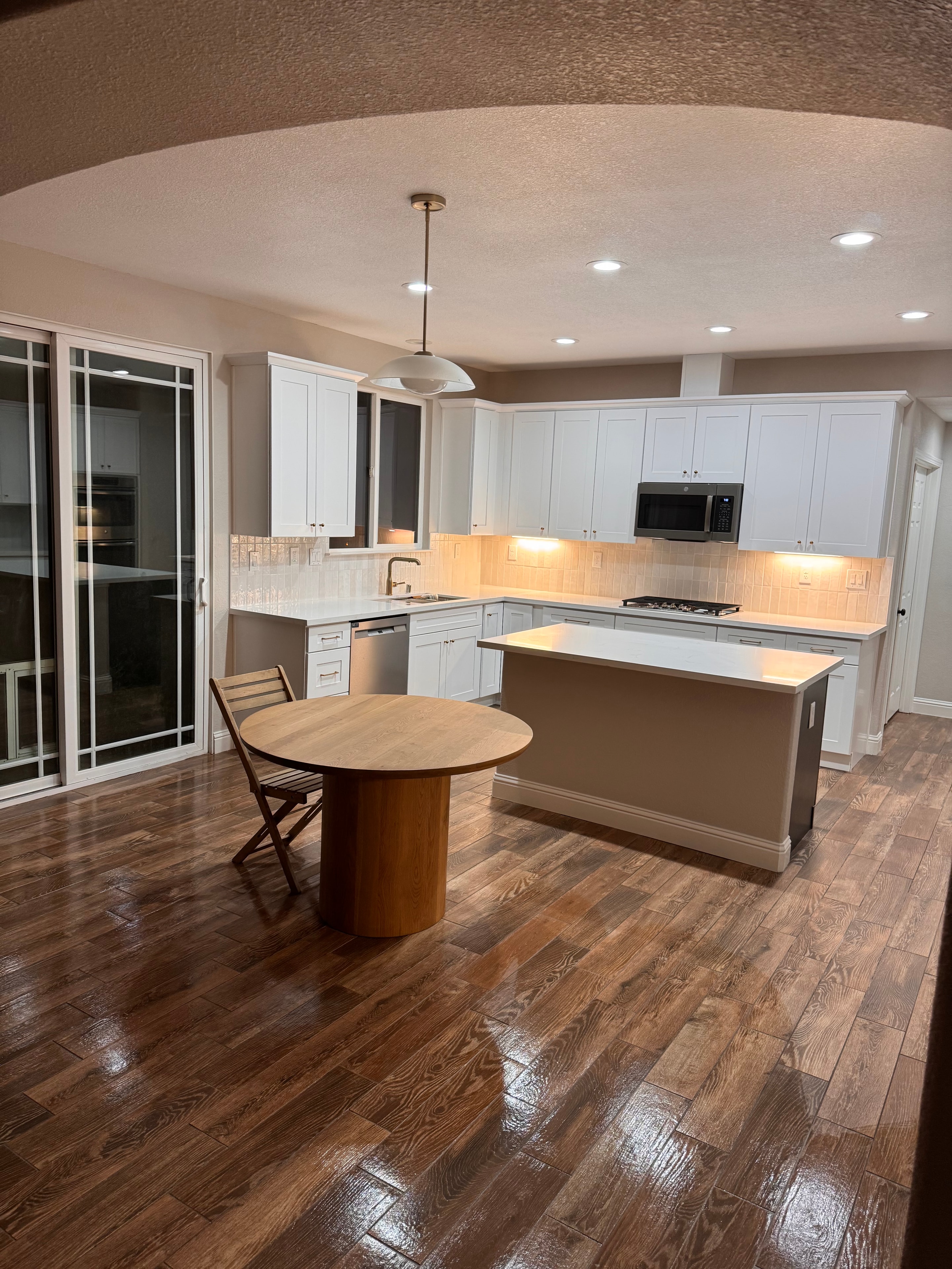 Kitchen remodel with white cabinetry and wood flooring