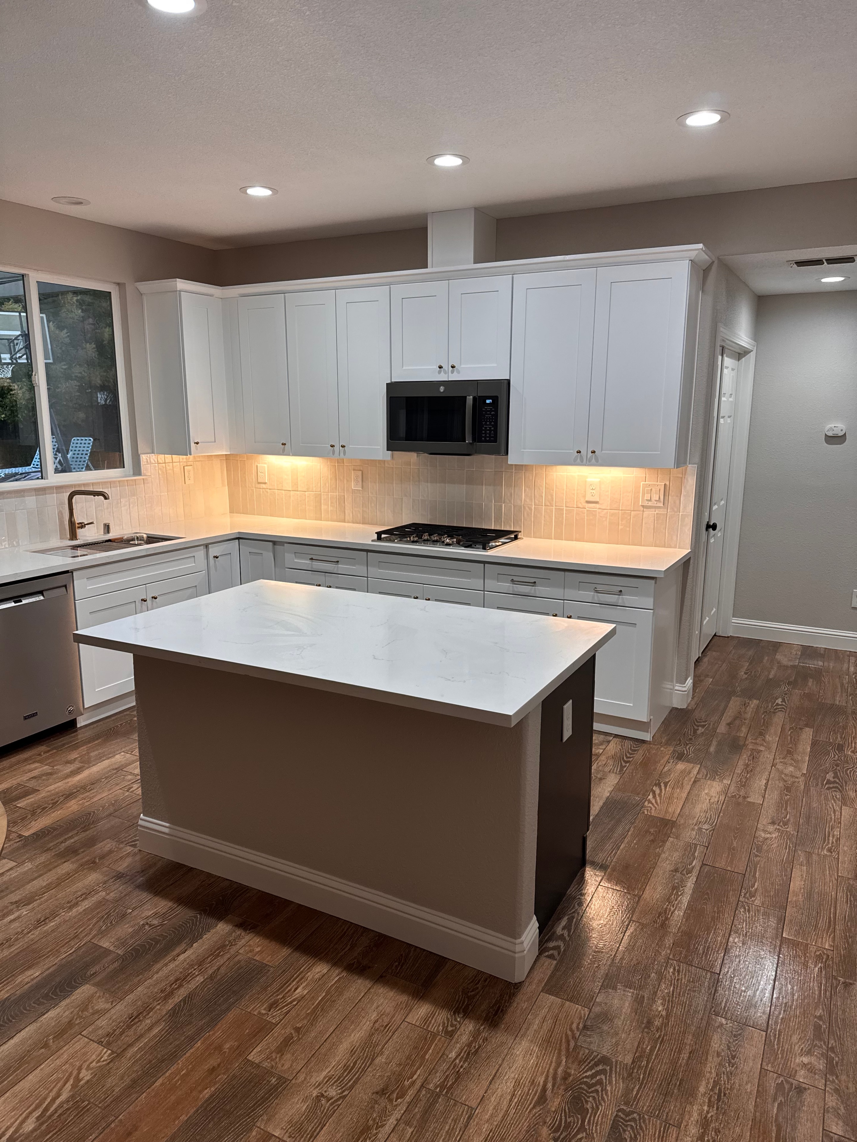 Kitchen remodel with white shaker cabinets and marble island